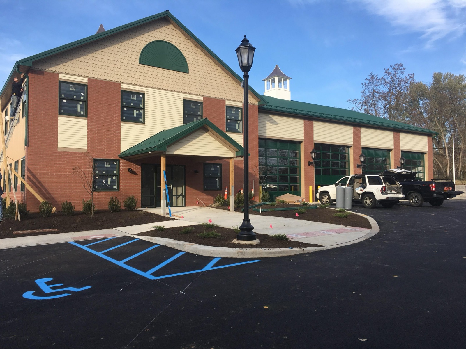 Completed firehouse in Milltown with green standing-seam roof and four bay doors